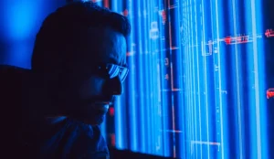 Cyber insurance renewal: will your claim actually be covered in an emergency? - A man in sunglasses intently studies a vibrant blue holographic screen, symbolizing digital technology
